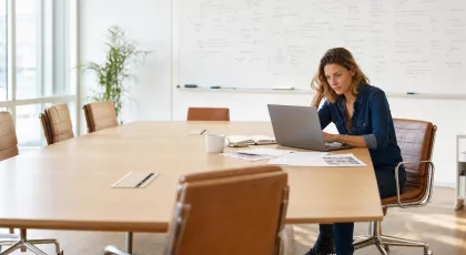 Consultante SEO en salle de réunion analysant un classement d'agences SEO