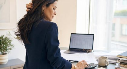 Femme en costume calculant des documents dans un bureau