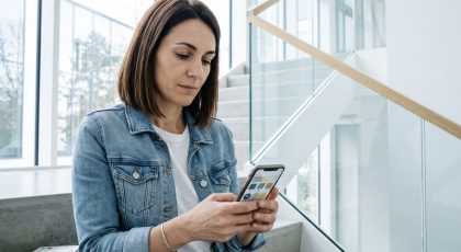 Femme consultant son smartphone dans un escalier moderne